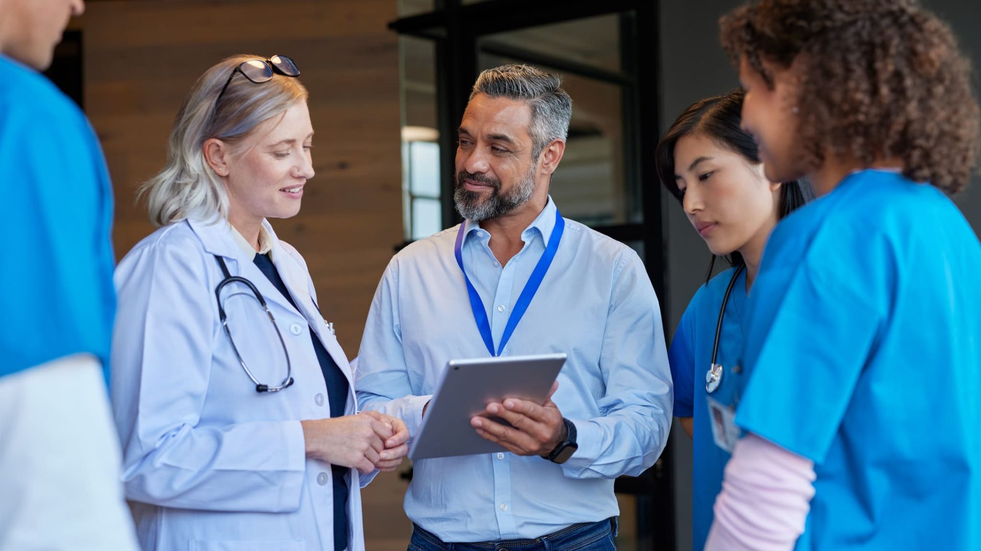 Équipe médicale en réunion utilisant un logiciel de gestion de personnel santé, Professionnel de la santé consultant son horaire sur mobile, Interface du logiciel Emprez pour la santé